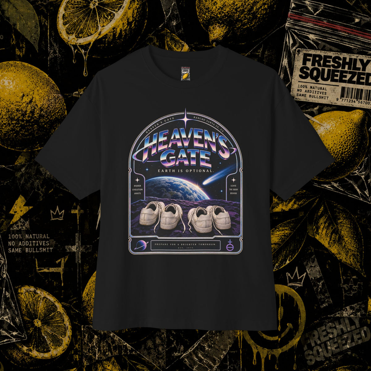 A black short-sleeve graphic T-shirt displayed flat against a dark, gritty background featuring lemon slices, stars, and a 'Freshly Squeezed' candy package. The shirt features a large circular graphic on the chest with the text 'HEAVEN'S GATE' and 'EARTH'S ORBITS' surrounding an illustration of three white sneakers on a purple and blue space scene.